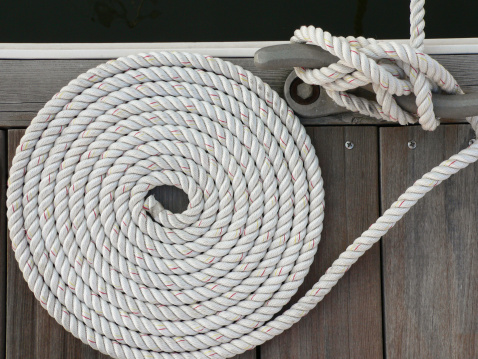 Neatly fastened and coiled mooring rope from a boat.Additional rope images: