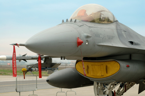 covered nose of an F 16 fighter plane parked in the airport