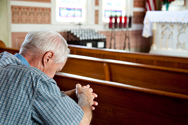 istock Senior man praying in church. 183291864