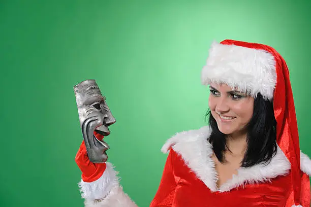 woman dresed in santa costume holding a mask