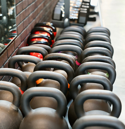 Assorted kettle bells lined up along wall