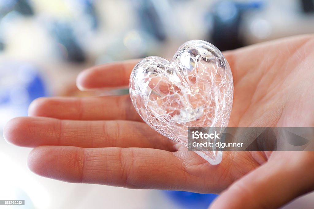 Mano che tiene un fragile cuore di vetro - Foto stock royalty-free di Accudire