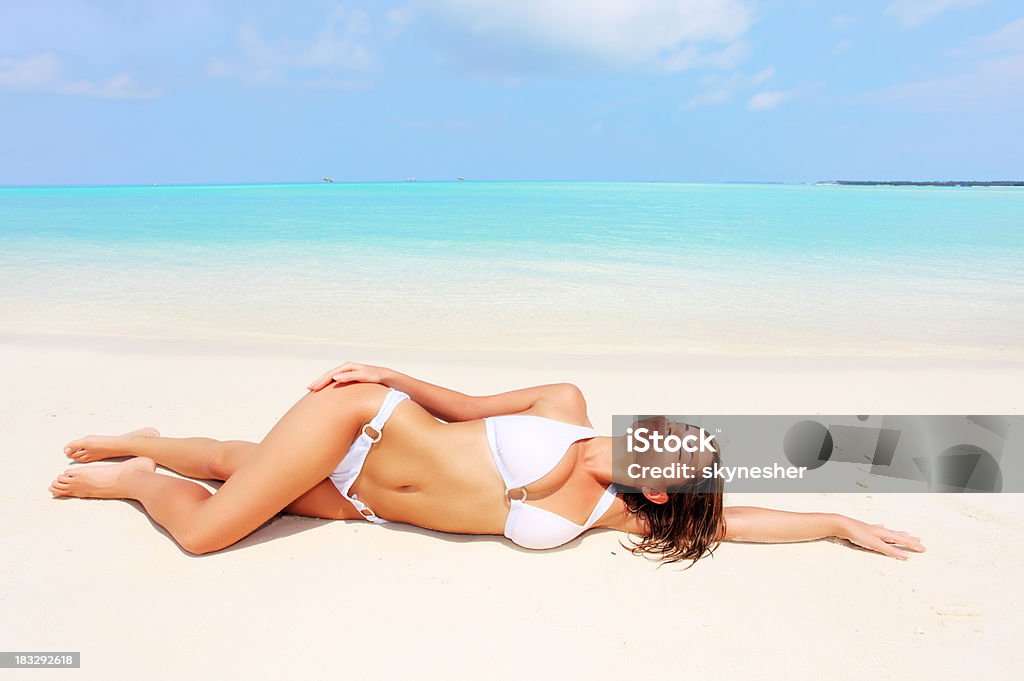 Bella donna sdraiata sulla sabbia in spiaggia tropicale. - Foto stock royalty-free di Abbronzarsi