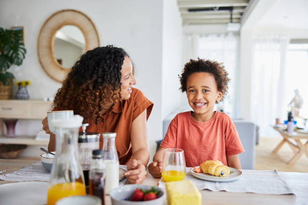 istock Mom and her little son laughing during breakfast at home 1832928534