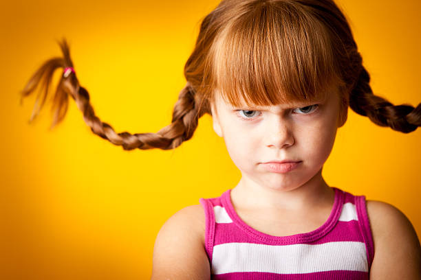 気難しいレッドヘア子羊の女の��子、2 ブレードおよび scowl - anger child braids braided ストックフォトと画像