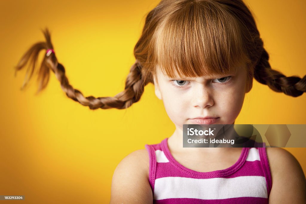 Grumpy Red-Haired Girl with Upward Braids and a Scowl "Whimsical, color photo of a grumpy, red-haired girl with upward braids and a scowl." Child Stock Photo