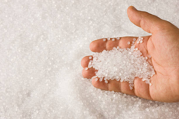 istock A hand sifting through a pile of clear plastic resin pellets 183293386