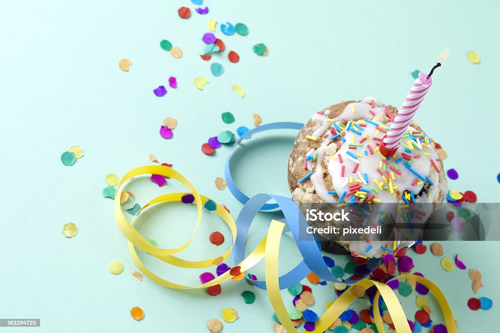 Cupcake con candela e coriandoli di luce - Foto stock royalty-free di Coriandoli