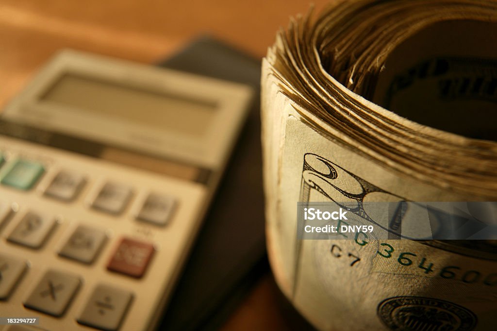 Bankroll and Calculator Roll of twenty's with checkbook and calculator Banking Stock Photo