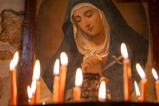 Burning candles in the church and Saint Mary painting. Mardin, Turkey - 30 October 2023.