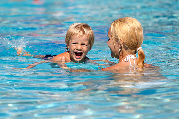 istock Mother learning child swimming in the pool on summer vacation 183295433