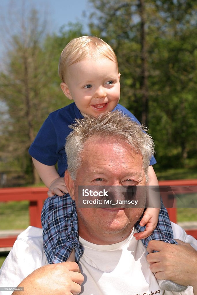 Il nonno Piggybacking - Foto stock royalty-free di Accudire