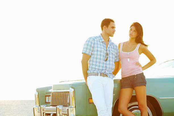 istock Relaxed young couple leaning against a car on the beach 183295608