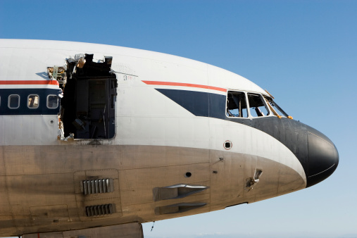 An An-2 plane is on the ground, an old plane in the neighborhood lies all sorts of junk.