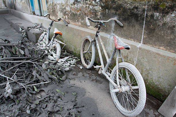 Bikes covered in volcanic ash. "Location: Muntilan, Yogyakarta, Indonesia.Date of photo: 6 November, 2010.The Mt. Merapi volcano in central-java erupted during October 2010. The eruptions was classified as its largest in over one century. Approximately 200.000 was evacuated from the most hard hit areas and a safety zone was set with a radius of 20km from the volcano. 300 people died between October and November 2010. Most of these in sudden outbursts of Pyroclastic flows. The eruptions covered many villages in thick volcanic ash. See more photos like this, and related in:" central java province photos stock pictures, royalty-free photos & images