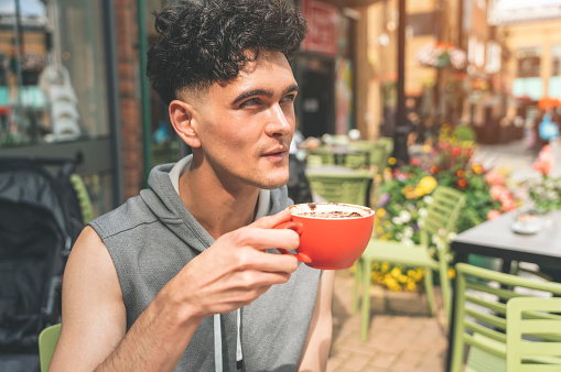 man having coffee at the street cafe and using laptop, lifestyle concept