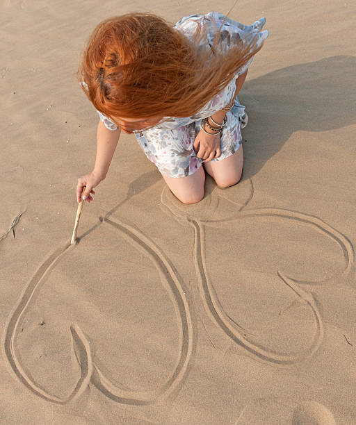 istock Young woman making two heart shape on the beach 183296109
