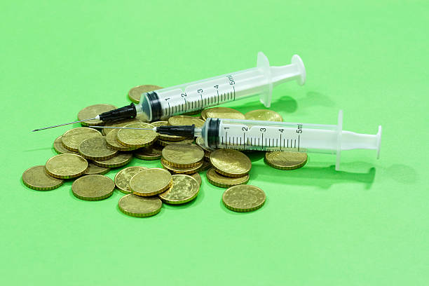 istock syringes on bunch of coins 183296308