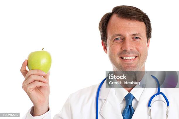 Feliz Médico Sostiene Apple Aislada Sobre Blanco Foto de stock y más banco de imágenes de Doctor - Doctor, Manzana, Agarrar