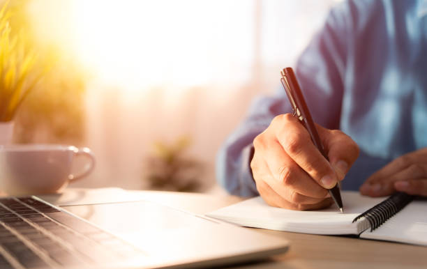 close-up of man hand using writing pen memo on notebook paper or letter, diary on table desk office. workplace for student, writer with copy space. business working and learning education concept. - dagbok bildbanksfoton och bilder