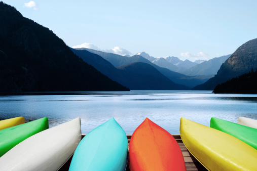 colorful canoes on dock with mountains and bright sky (XL)