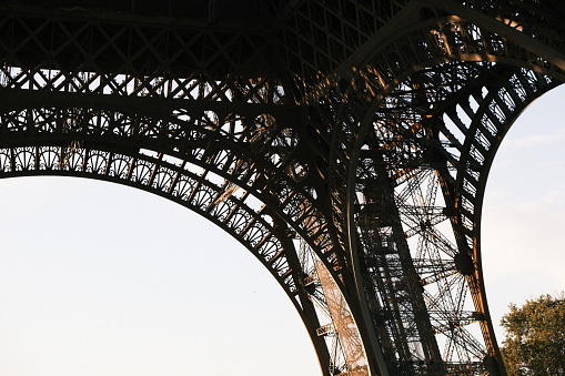 The exterior of the Eiffel Tower, photographed from the grounds, photographed during golden hour, in landscape.