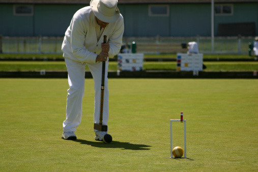 Man playing a game of Croquet.