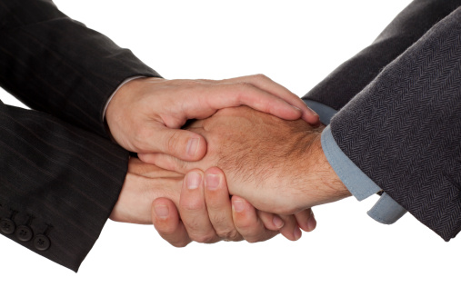 Two caucasian businessmen shaking hands touching with second hand top and bottom isolated on white.
