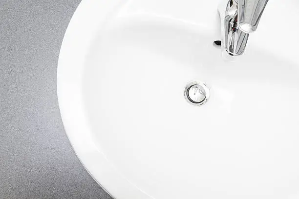 Clean simple white washbowl from above. Faucet and sink visible.More of this series: