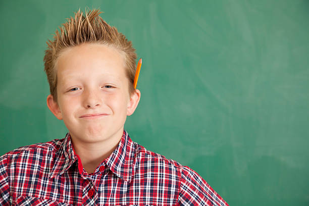 istock Happy Young Boy at School In Front of Chalkboard 183297567