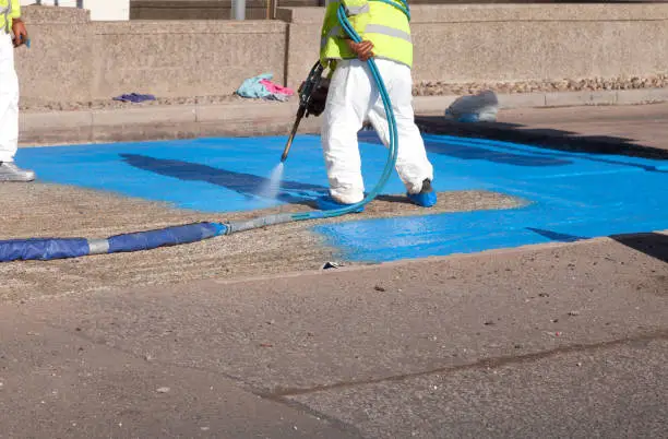 Photo of Workforce spraying a waterproof layer membrane to new road construction