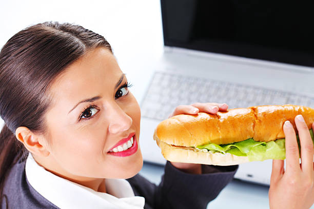 istock Young business woman eating a sandwich. 183298115