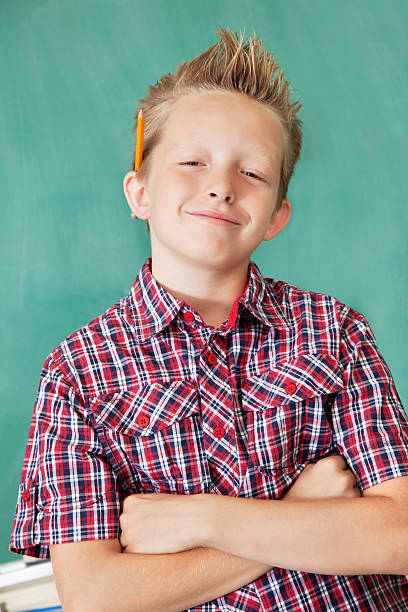 istock Confident Young Student With Arms Crossed in Front of Chalkboard 183298529