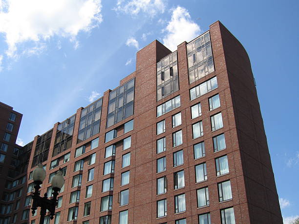 istock A tall apartment building against a cloudy blue sky 183298766
