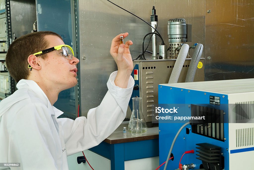 Étudiant ou scientifique examine goûtez dans une bouteille - Photo de Assistant chimiste libre de droits