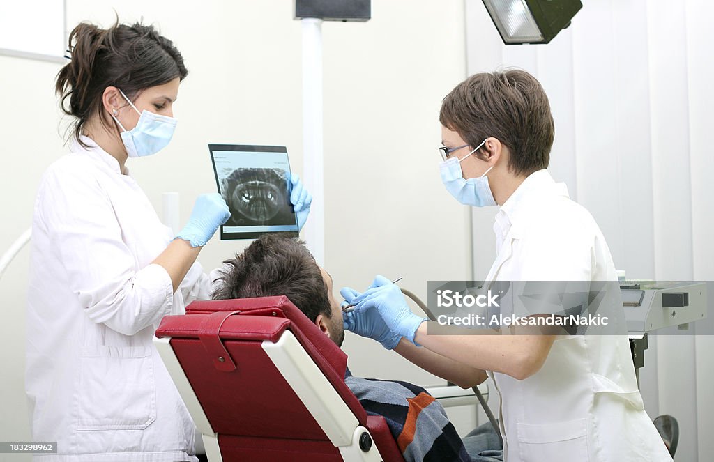 Стоматолог-команда работает на пациента - Стоковые фото Белый роялти-фри