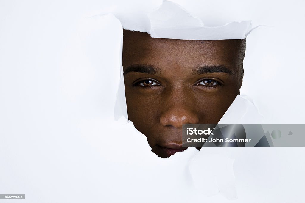 Mężczyzna patrzy przez podarty ściany - Zbiór zdjęć royalty-free (Afroamerykanin)