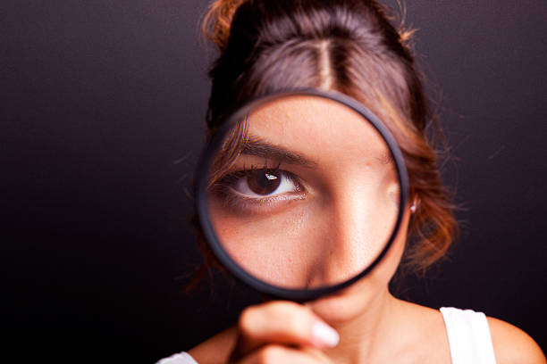 istock Girl looking through a magnifying glass 183299059