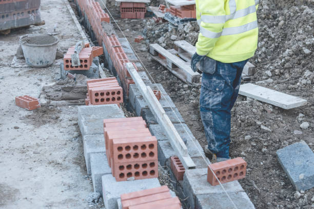 murarz układający cegłę na mieszance cementowej na budowie z bliska. zmniejsz kryzys mieszkaniowy, budując bardziej przystępne cenowo domy - cenowo zdjęcia i obrazy z banku zdjęć