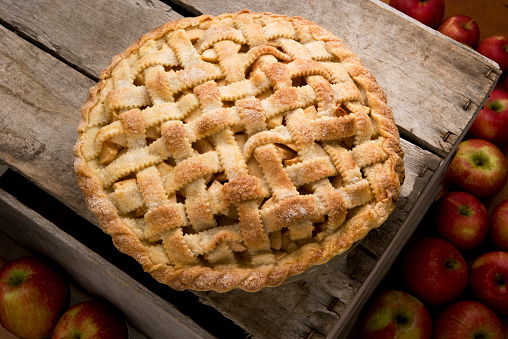 Lattice top apple pie on wooden crate.