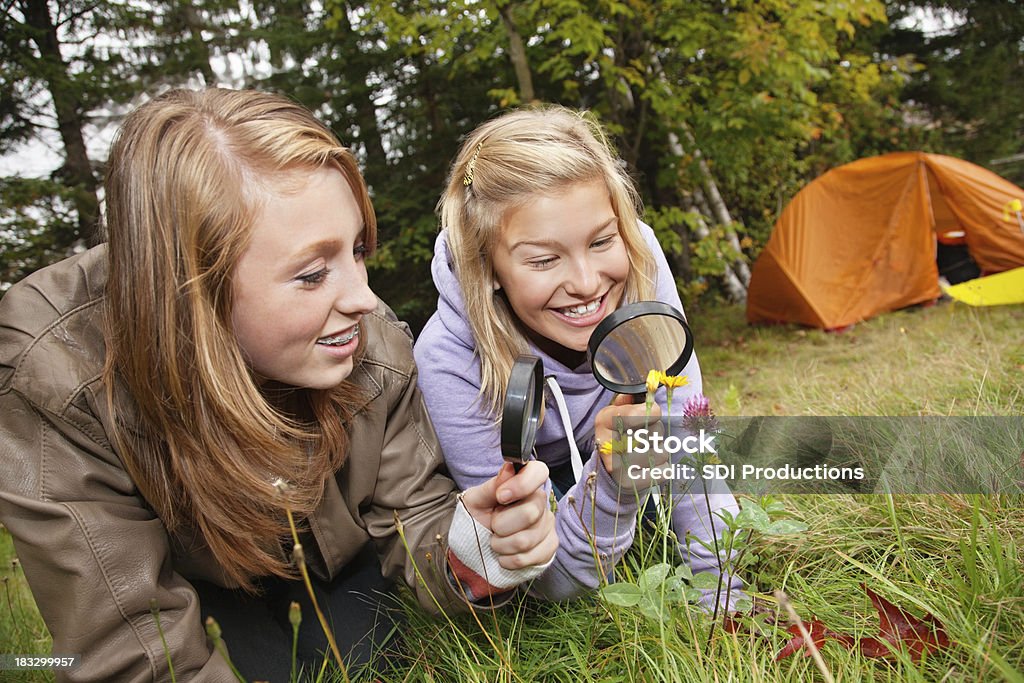 Felices amigos explorar la naturaleza con lupa - Foto de stock de Actividades recreativas libre de derechos