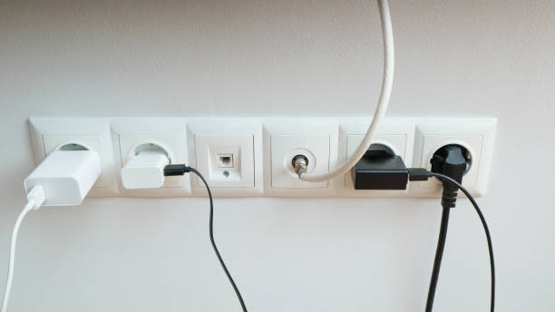istock Many chargers plugged into maltiple electrical outlet on white background. Concept of electricity consumption. 1833000996