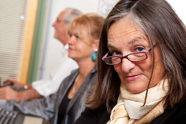 istock Senior Adult at a Computer Lab With Other People 183300189