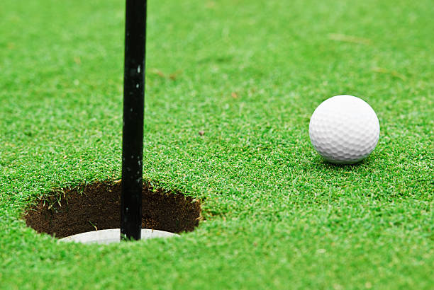 istock golf ball near hole 183300225