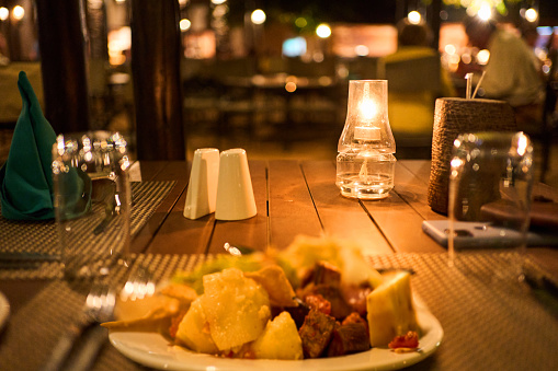 Close-up of a gourmet dinner sitting on a candlelit table in the lodge restaurant of a national park