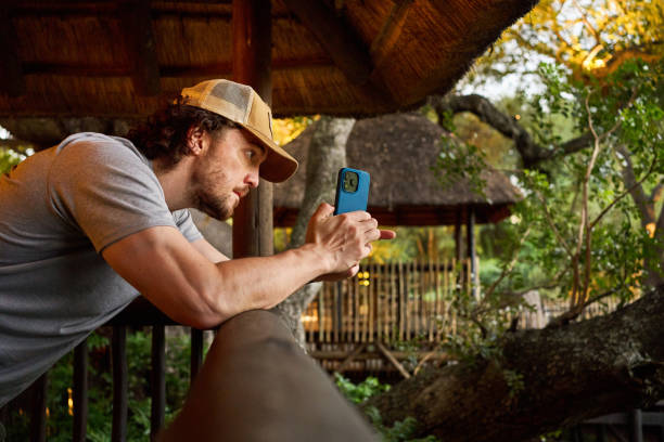 istock Young man taking a photos from a wildlife reserve viewing platform 1833004198