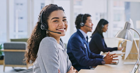 Call center woman, happy and portrait at help desk, job and staff group with computer, advice and office. Telemarketing agent, pc and microphone with headphones, consulting or listen for tech support