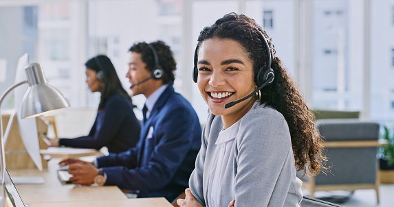 Call center woman, smile and portrait at headphones, job and staff group with computer, advice and office. Telemarketing agent, pc and microphone at help desk, consulting or listen for tech support