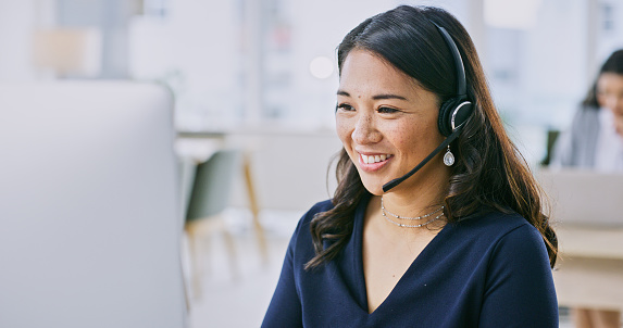 Woman, smile on computer and call center communication, customer service or e commerce support in office. Professional advisor, virtual assistant or Asian consultant for contact us and business FAQ