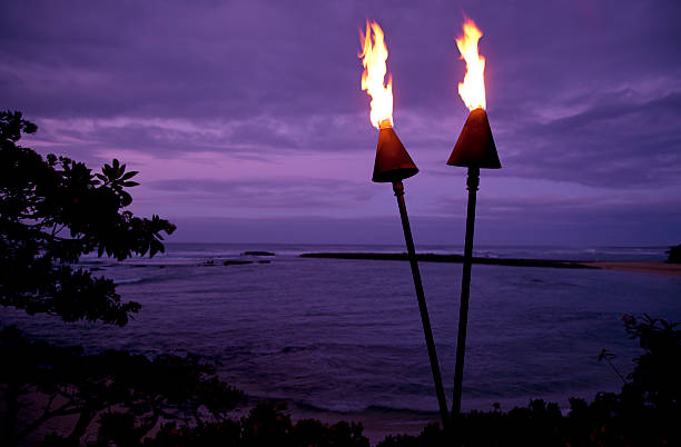 тики torches в гавайи на закате - tiki torch стоковые фото и изображения